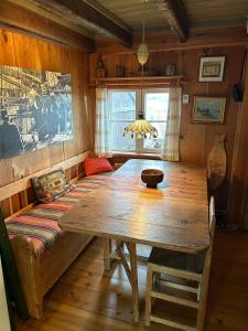 a dining room with a wooden table and a couch at Stuga med havsutsikt in Strömstad