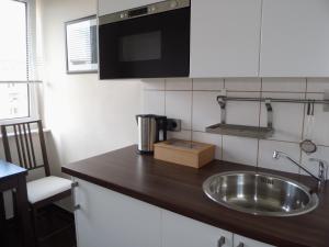 Una encimera de cocina con fregadero y microondas. en Apartment S - perfect stay, en Leipzig 23 fotos más