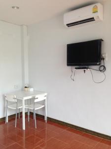 a room with a white table and a tv on the wall at Bai Pai Resort in Khlung