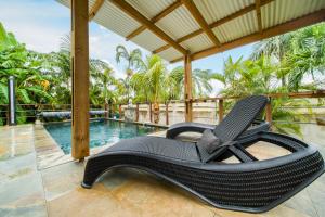 a black chair sitting on a porch next to a swimming pool at La Mezina in Saint-Joseph