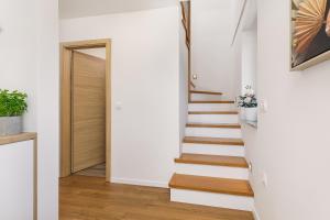 a staircase in a home with white walls and wooden floors at Vila Šenčur in Šenčur