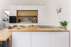a kitchen with white cabinets and a wooden counter top at Vila Šenčur in Šenčur
