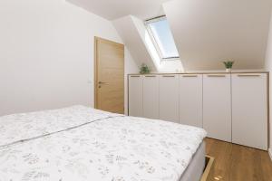 a white bedroom with a bed and a window at Vila Šenčur in Šenčur