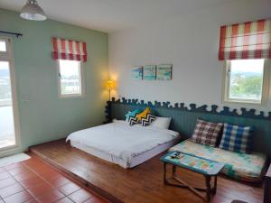 a bedroom with two beds and a table and a couch at Mei Shiou B&B in Dongshan