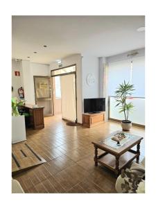 a living room with a coffee table and a television at Pension Villa ** in Comillas +33 photos