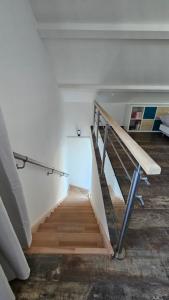 a staircase in a room with white walls and wooden floors at L'escale Aéro Lyon in Saint-Laurent-de-Mure +4 photos