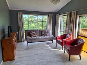 a living room with a couch and two chairs at Wheel Inn in New Plymouth