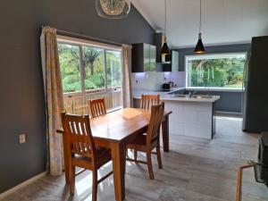 a kitchen and dining room with a wooden table and chairs at Wheel Inn in New Plymouth