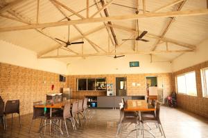a large room with wooden tables and chairs at Vanray Farm And Resort in Talala