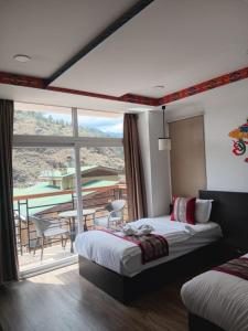 a hotel room with a bed and a balcony at Hotel Ugyen, Thimphu in Thimphu +86 photos