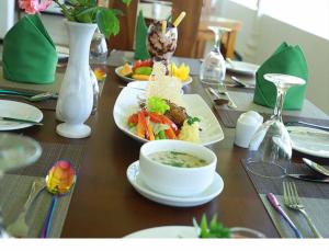 a table with plates of food and a bowl of soup at Golden Ridge Sigiriya in Dambulla
