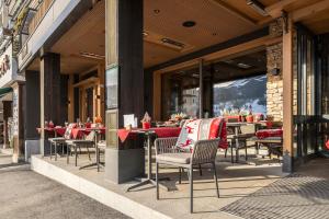 a restaurant with tables and chairs in front of a building at Hotel Central Wolter - Grindelwald in Grindelwald