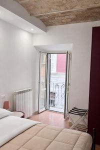a bedroom with a bed and a view of a balcony at Boca Luxury Rooms in Tarquinia