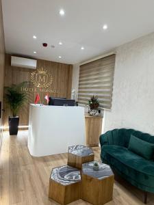 a living room with a couch and a table at Hotel Monaco in Kamëz