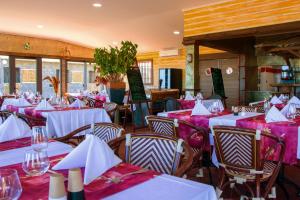 a restaurant with white tables and chairs with purple tablecloths at Gadiamb City in Saint-Pierre
