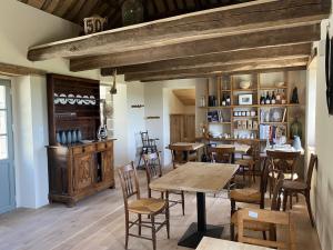 a dining room with tables and chairs and a book shelf at les jardins de la Matz in Plouër-sur-Rance