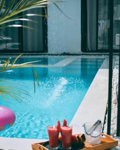 a tray of fruit and drinks next to a swimming pool at White Tiger Villa in Goa