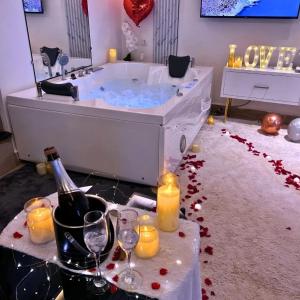a bath tub with a bottle of wine and candles at White Tiger Villa in Goa