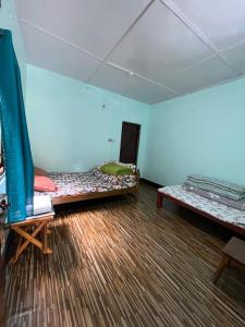 a room with two beds in a room with blue walls at Jumusing homestay in Rupa +5 photos