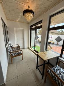 a living room with a table and chairs and a chandelier at Black & White Guest House in Parow +89 photos