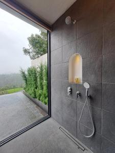 a bathroom with a shower with a glass door at Bali De Pardis Cottage in Munduk +77 photos