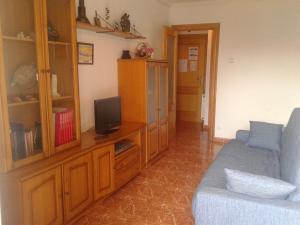 a living room with a couch and a tv and a cabinet at Apartamento en Isla Playa in Isla