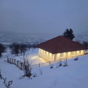 a building with lights on it in the snow at Kuća snova in Ilijaš