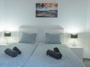 a bedroom with two beds with slippers on them at CASA IBON 1A pool view Playa Roca in Costa Teguise +9 photos