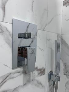 a bathroom with white marble walls and a mirror at Hotel Berati in Berat