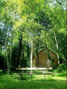 a bench sitting in the grass in front of a cabin at Chez Elise et Joseph in Mons-Boubert +4 photos