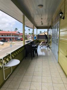 a porch with chairs and a table on a building at staylikehome guesthouse in Nieuw Nickerie