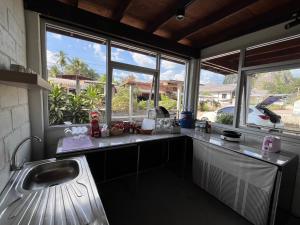 a kitchen with a sink and some windows at ค้างคาวกินกล้วยโฮมสเตย์ in Ban Mung