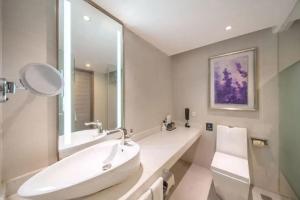 a white bathroom with a sink and a mirror at Lavande Hotel Xi'an Bell Tower in Xi'an