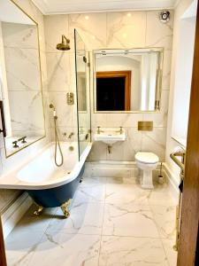a bathroom with a tub and a sink and a toilet at Purbeck House Hotel & Louisa Lodge in Swanage +107 photos