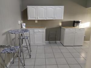 a kitchen with white cabinets and bar stools at Ocean River in Gqeberha