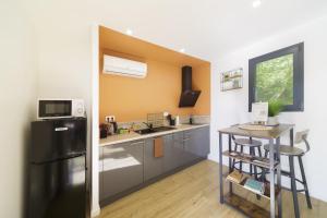 a kitchen with a black refrigerator and a counter at Les cabanes du Lac in Sévignac-Thèze