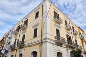 a yellow building with balconies on the side of it at Tiare' in Trani