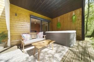 a bath tub sitting on the deck of a house at Les cabanes du Lac in Sévignac-Thèze +8 photos
