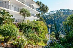 an apartment building with plants and a street light at Apartamentos Cala Llevado in Tossa de Mar