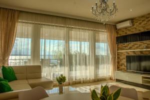 a living room with a couch and a large window at RoApart Riva Lake Studiouri si Apartamente 2-3 camere cu vedere lac -parcare privata in Mamaia