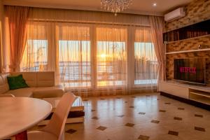 a living room with a couch and a tv and a table at RoApart Riva Lake Studiouri si Apartamente 2-3 camere cu vedere lac -parcare privata in Mamaia