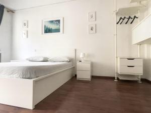 a white bedroom with a bed and a night stand at ApartmentsPadova in Padova
