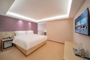 a bedroom with a white bed and a flat screen tv at Lavande Hotel Xi'an Bell Tower in Xi'an +21 photos