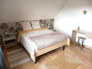 a bedroom with a bed and a table at A l'Orée du Bois ''Les Hêtres'' in Guewenheim