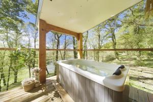 a bath tub on the deck of a tree house at Les cabanes du Lac in Sévignac-Thèze
