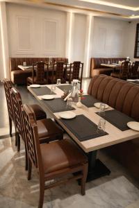 a dining room with a long table and chairs at The Indies 365 Hotel in Bangalore