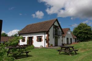 um chalé branco com mesas de piquenique no quintal em The White Horse Inn em Calne