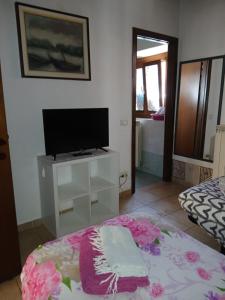 a living room with a tv and a bed with a table at B&B Mirna - Piccolo Appartamento in Vaprio dʼAdda