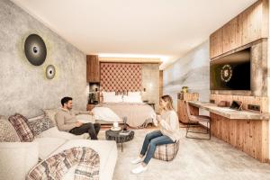 a man and a woman sitting in a living room at Biohotel Bergzeit in Zöblen