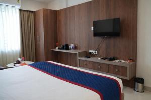 a hotel room with a bed and a flat screen tv at The Indies 365 Hotel in Bangalore